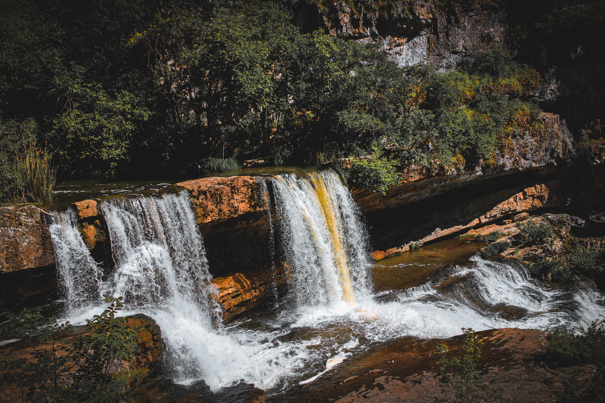 Deux des cascades inférieures de Mirusha se déversant sur un gradin de calcaire rouge dans la gorge, au printemps