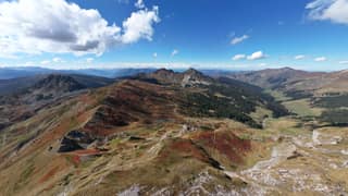 Autumn-red ridges of Bjeshkët e Nemuna seen from the air on the Kosovo side of the tri-border peaks
