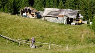 The shepherd huts of Milishevc in the Rugova mountains with a herder at the fence