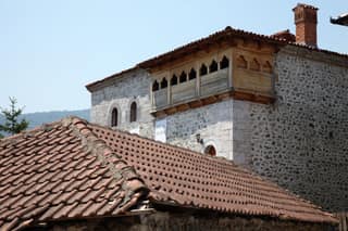 The stone kulla of the Oda e Junikut with its carved wooden gallery and tiled roofs
