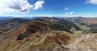 Autumn-red ridges of Bjeshkët e Nemuna seen from the air on the Kosovo side of the tri-border peaks