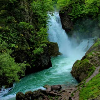The source of the Drini i Bardhë bursting from the cliff at Radavc near Peja into a green gorge