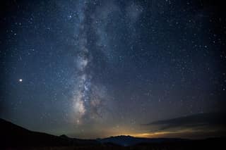 The Milky Way standing over a dark ridge at 2,300 m in the Sharr Mountains above Dragash