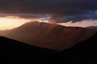 The last light of the day on the long ridge of Oshlak under storm clouds, opposite the Sharr Mountains