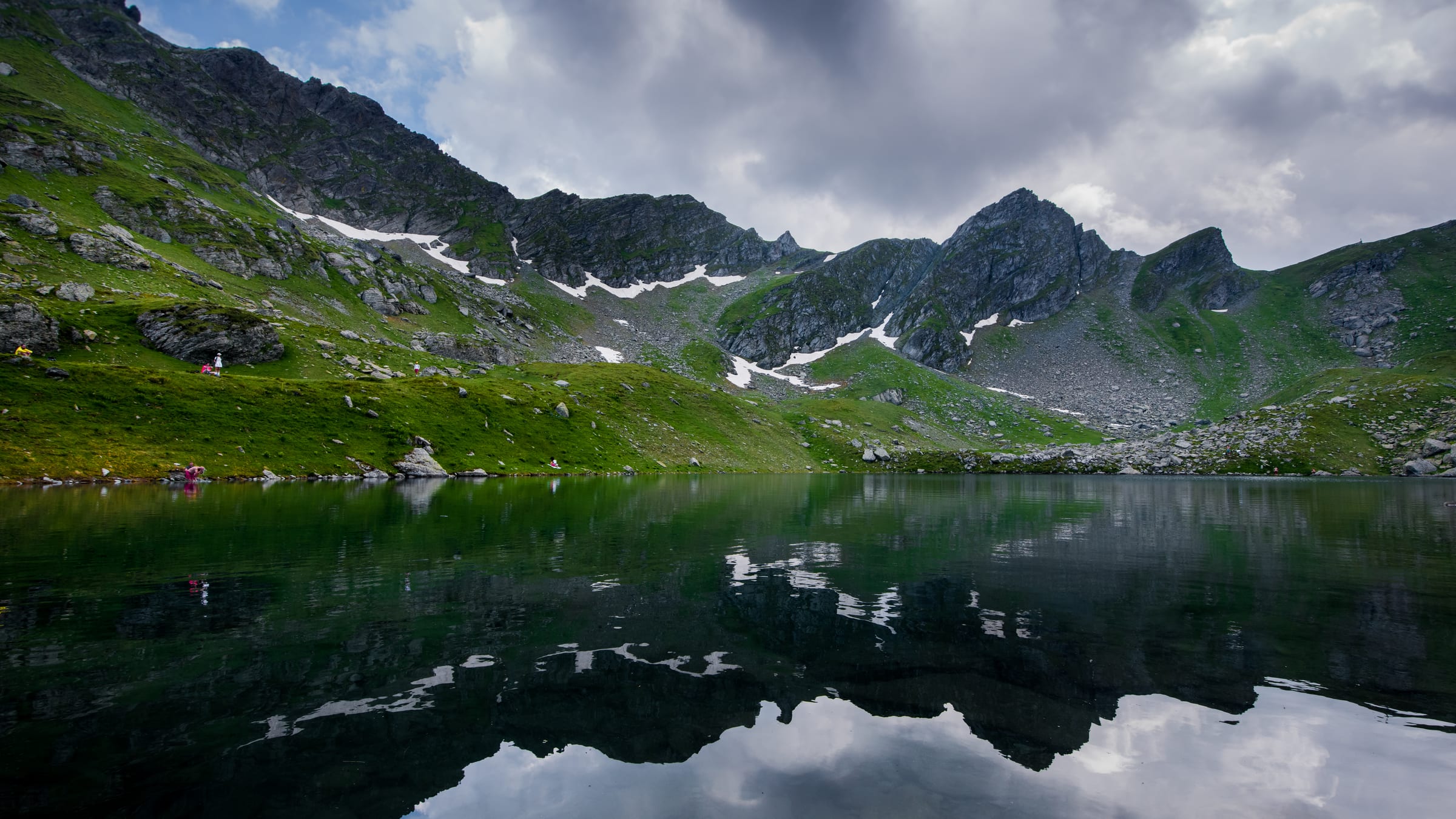 Des nuages d'orage reflétés dans le Liqeni i Zemrës, le lac du Cœur, sous le cirque des montagnes de Deçan
